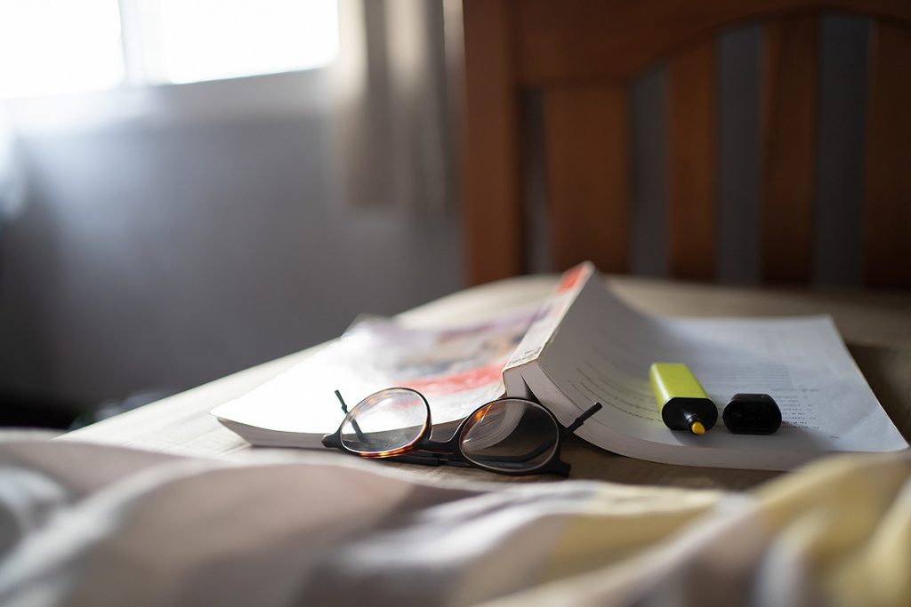 ベッドにある参考書とメガネ
