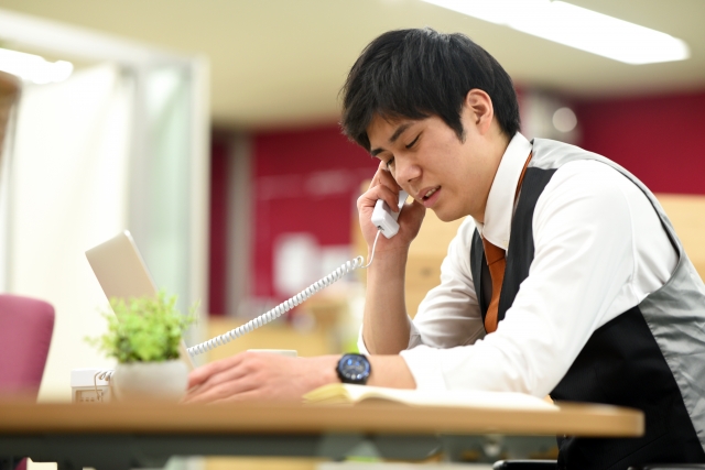 落ち込み辛い電話をする男性